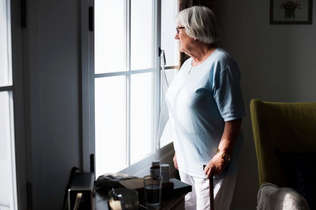 senior woman standing alone at home
